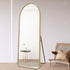 Freestanding arched mirror with gold aluminium frame reflecting room light