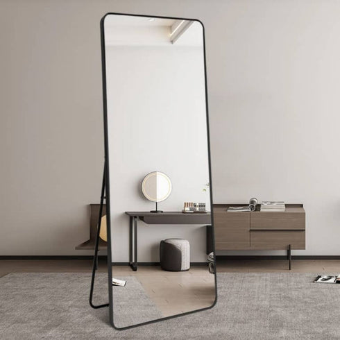 Black rounded edge freestanding mirror styled in a living room