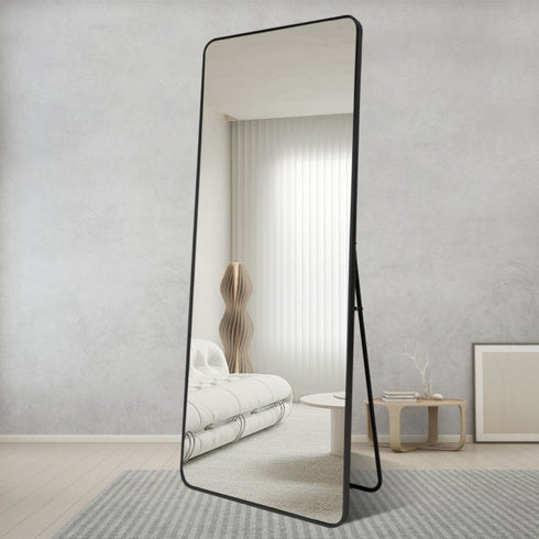Large black full-length mirror brightening a contemporary living room