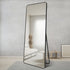 Large black full-length mirror brightening a contemporary living room