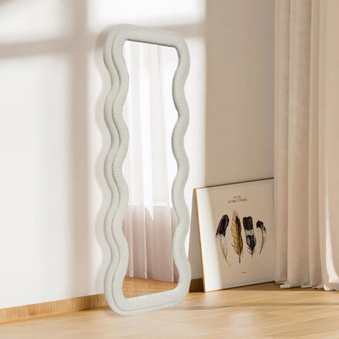 Vertical wavy frame white velvet mirror styled in a modern bedroom interior
