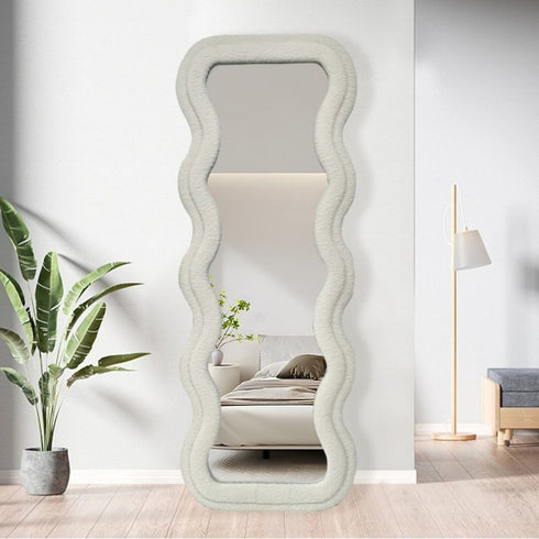 Soft white velvet mirror leaning in a bright modern living room interior