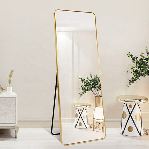 Large gold floor mirror with rounded corners adding elegance to a foyer
