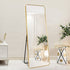 Large gold floor mirror with rounded corners adding elegance to a foyer