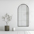 Front view of Aven arched black wall mirror in living room