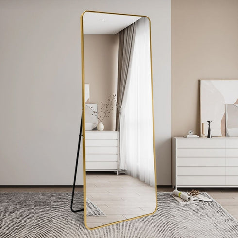 Tall gold mirror reflecting light in a modern living room setting