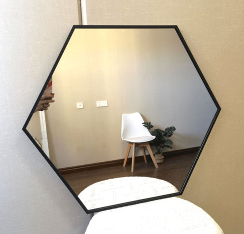 Decorative hexagonal mirror enhancing a minimalist bedroom