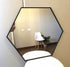Decorative hexagonal mirror enhancing a minimalist bedroom