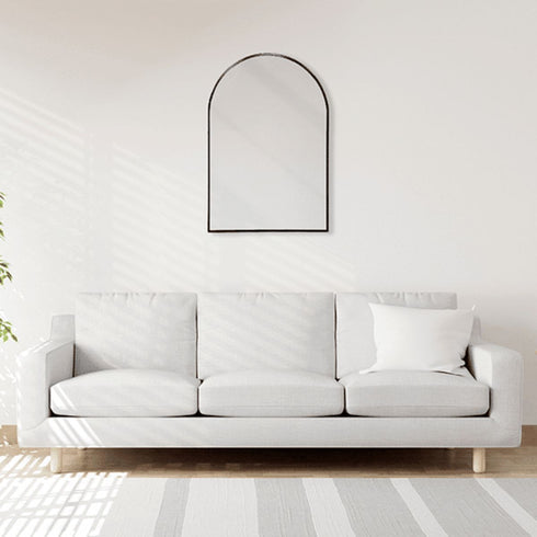Wall-mounted arched mirror with black frame enhancing a modern living room interior