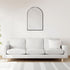 Wall-mounted arched mirror with black frame enhancing a modern living room interior