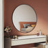 Side angle showing slim profile of black round wall-mounted mirror