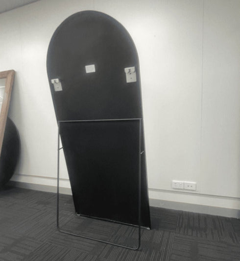 Back profile of Coen arched mirror highlighting lightweight freestanding construction