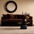 Black and brass Cecille Round Mirror hung above sofa in living room