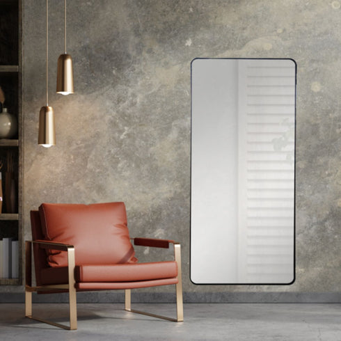 Contemporary black wall mirror reflecting light in living interior