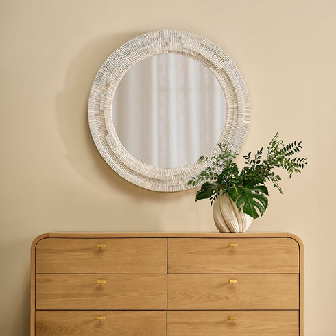 Handcrafted Dani white wall mirror reflecting light in entryway interior